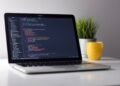 Developer coding with AI tools on laptop