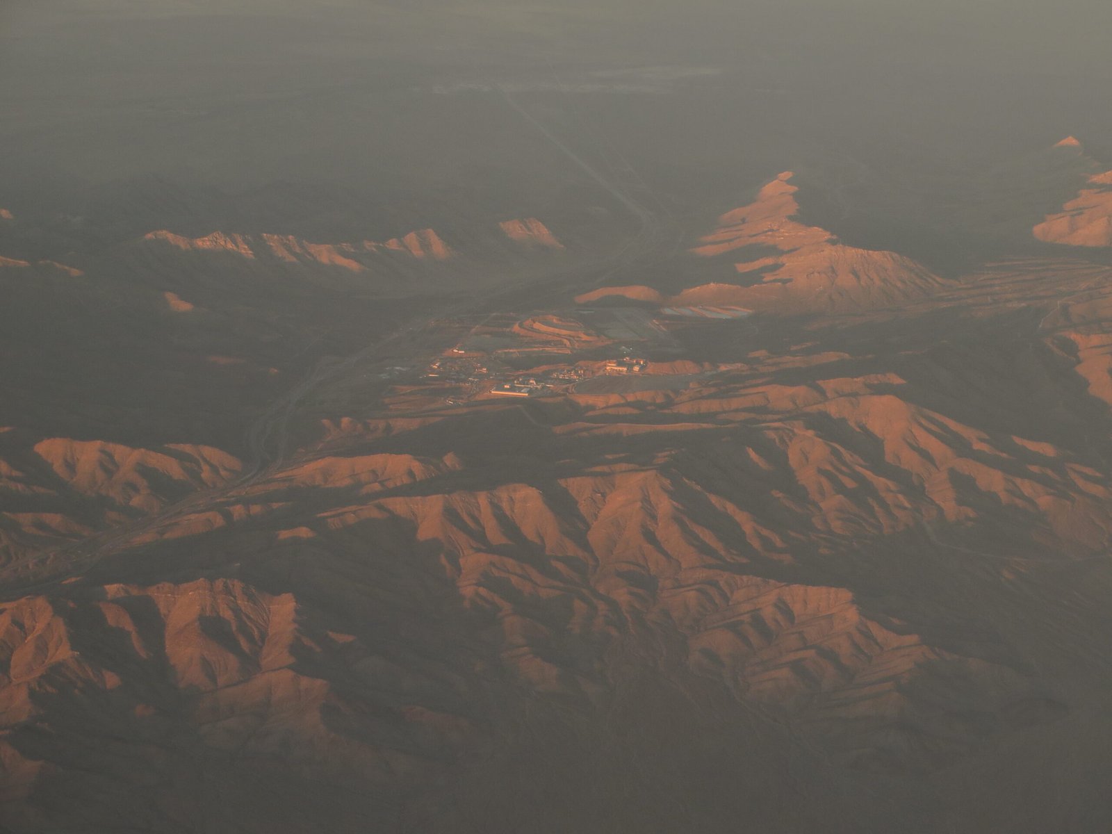 Aerial view of Mountain Pass Rare Earth Mine in California showing the open-pit mining operation and processing facilities in a desert landscape