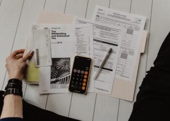 Financial documents, charts and a calculator on a desk