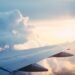 Aircraft wing above a layer of cloud at altitude