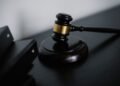 A wooden judge gavel resting on a dark surface