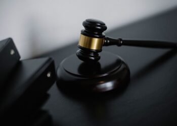 A wooden judge gavel resting on a dark surface