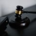 A wooden judge gavel resting on a dark surface