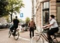Cyclists riding along a busy street in Amsterdam