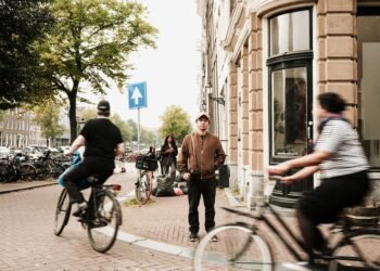 Cyclists riding along a busy street in Amsterdam