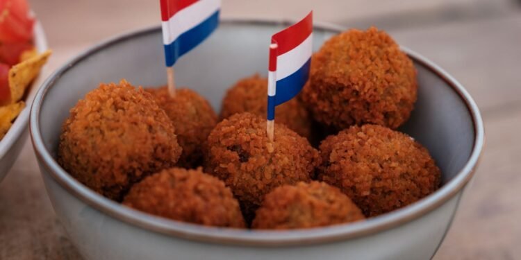 Dutch bitterballen in a bowl with small Dutch flags on a cafe terrace