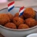Dutch bitterballen in a bowl with small Dutch flags on a cafe terrace