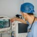 Clinician in scrubs reviewing data on a monitor