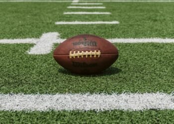 American football resting on a yard line