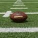 American football resting on a yard line