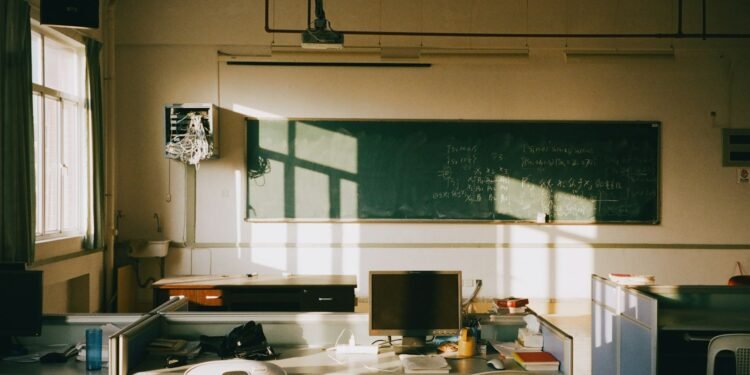 Sunlight streaming into an empty classroom with rows of desks