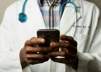 Clinician reviewing patient data on a laptop with a stethoscope nearby