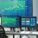 Empty trading desk with multiple monitors showing market data