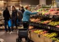 Shoppers in the fruit and vegetable aisle of a Dutch supermarket