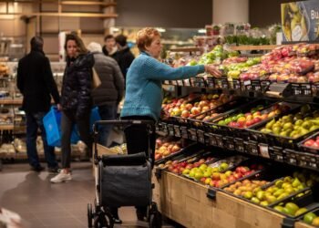 Shoppers in the fruit and vegetable aisle of a Dutch supermarket