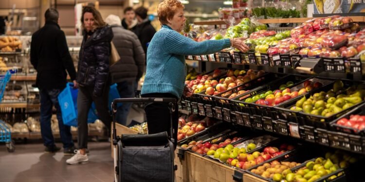 Shoppers in the fruit and vegetable aisle of a Dutch supermarket
