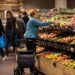 Shoppers in the fruit and vegetable aisle of a Dutch supermarket