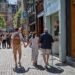 Shoppers walking along a pedestrian shopping street with a tram