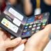 iPhone Duo foldable held open in two hands showing the iOS home screen